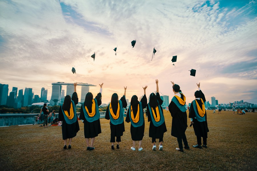 University graduates celebrating together with their graduation caps in the air